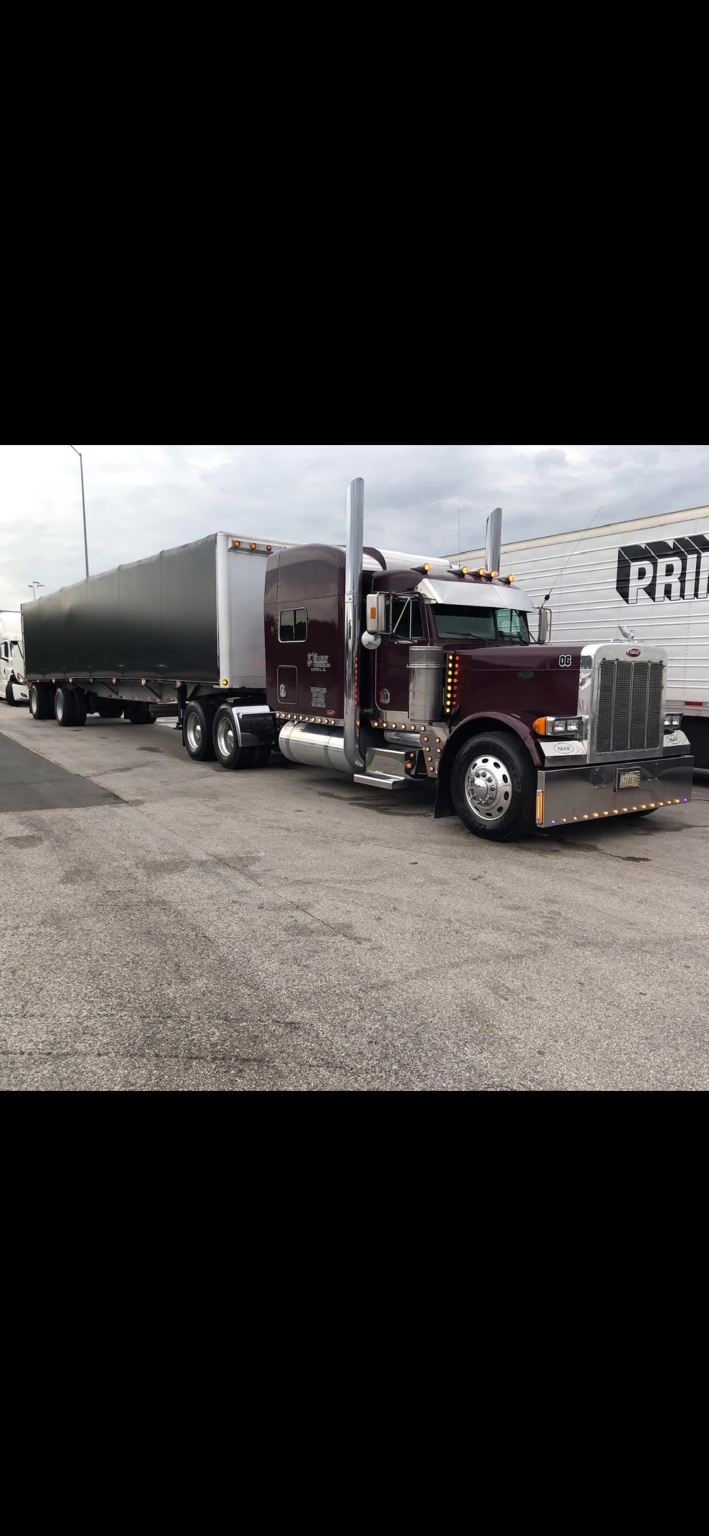 Burgundy truck coupled to a Conestoga trailer